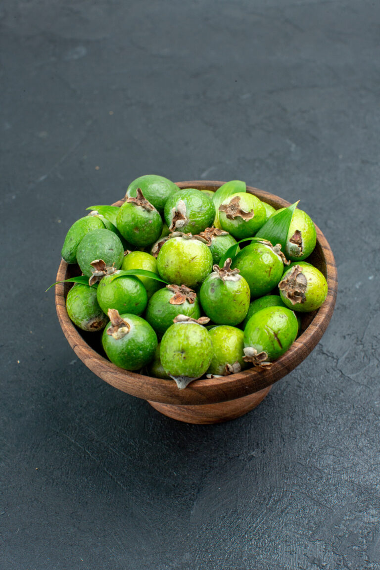 bottom-view-fresh-feijoas-wooden-bowl-dark-surface