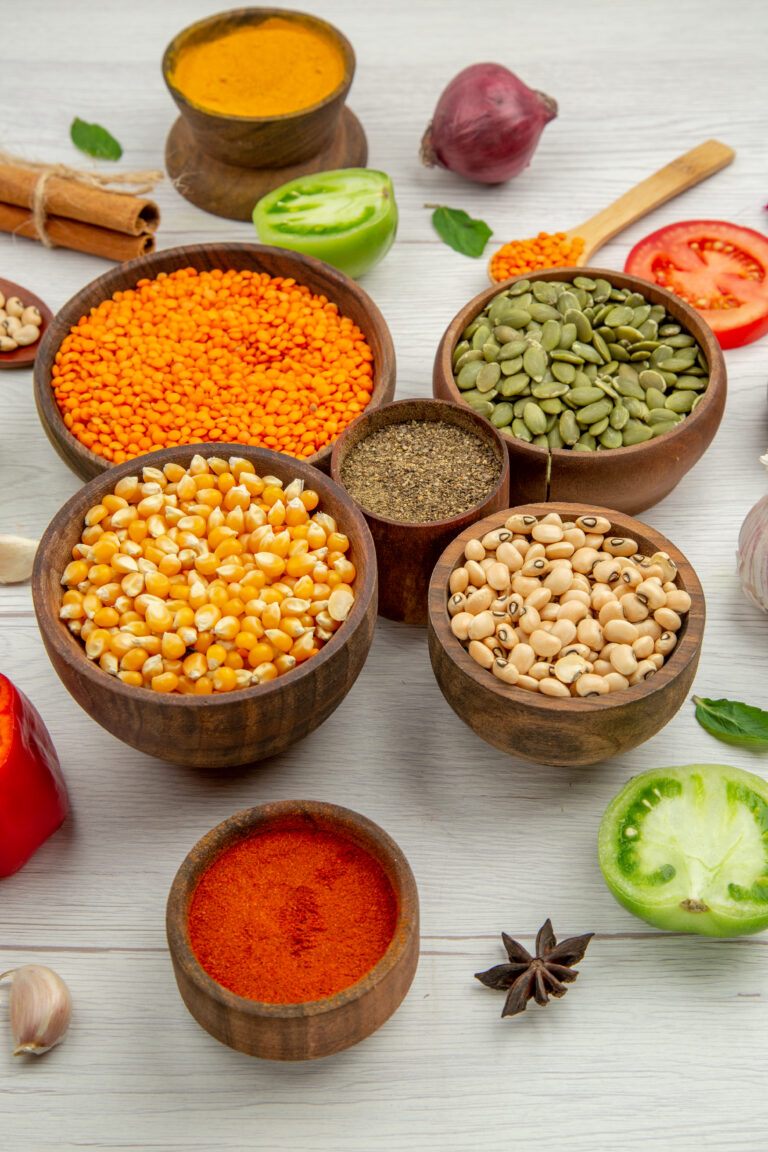 bottom-view-wooden-bowls-with-corn-seeds-beans-pumpkin-seeds-lentiles-black-pepper-bowl-cinnamon-anise-table